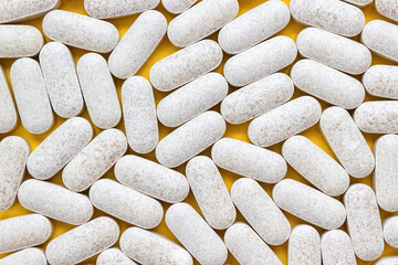 Сapsules with vitamin C on yellow background. Dietary supplements as a source of citrus bioflavonoid. Selective soft focus