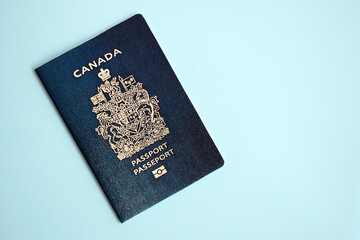 Canadian passport on blue background close up. Tourism and citizenship concept