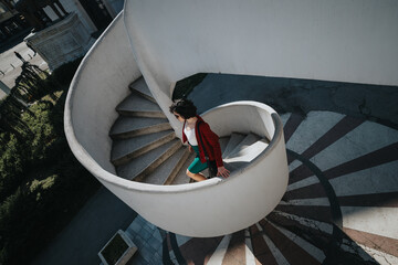 A professional businesswoman in formal attire steps down a spiral staircase, embodying confidence...