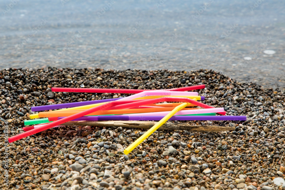 Wall mural colorful single use plastic straws garbage washed up on the beach illustrating stop pollution