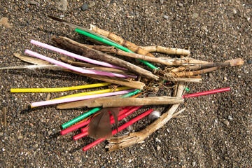 colorful single use plastic straws garbage washed up on the beach illustrating stop pollution