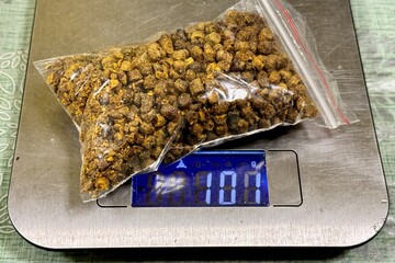 A transparent package of bee pergi as called ambrosia weighing 100 grams is on the scales for sale....