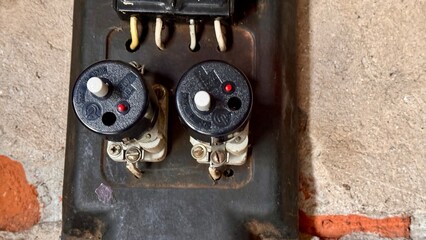Black antique household electricity meter with push-button type electric fuses in the garage....