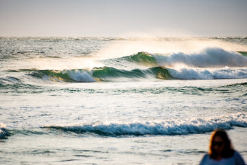 Small sunlit breaking waves near the shore