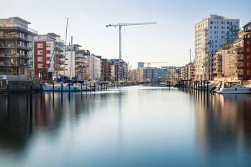 Serenity meets urban growth at a Dockan Marina in Malmö, where boats dock in calm waters ....