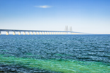 The Oresund Bridge stretches across the blue sea, a feat of engineering linking Malmö to Copenhagen. Concepts: connection, travel, engineering, Malmo