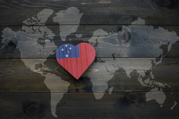 wooden heart with national flag of Samoa near world map on the wooden background.