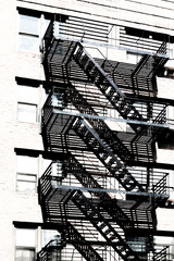 looking up at metal fire escape stairs and balconies on an old building