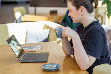 Focused Woman with Coffee Engrossed in Laptop Work