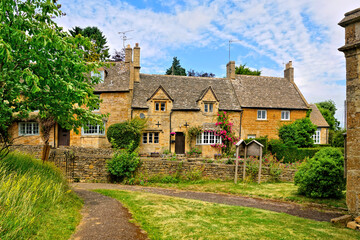 Fototapeta na wymiar Pretty Cotswolds village under blue skies, Bourton on the Hill, Gloucestershire, England