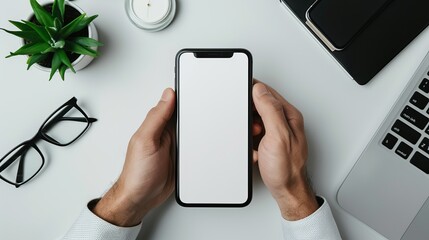 Close-up of a businessman's hands using a mockup of a smartphone at a white office desk. Mobile phone with a blank screen for montaging graphic displays - obrazy, fototapety, plakaty
