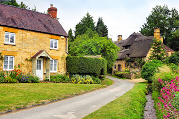 Fototapeta na wymiar Beautiful Cotswolds village with thatched roof house and flowers, Stanton, Gloucestershire, England