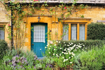 Charming Cotswolds house front with flowers, Gloucestershire, England