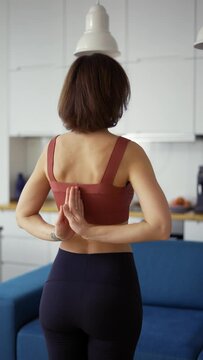 Rear view of a woman connecting hands behind her back, yoga concept