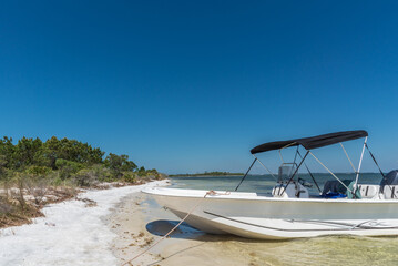 A boat pulled up on the shore on a beautiful Summer day. Shell Island, St. Andrews State Park, Panama City Florida