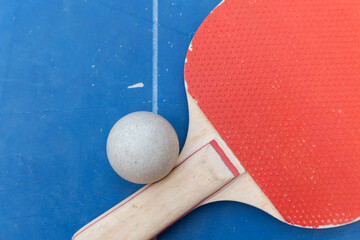 top view pingpong racket and ball and net on a blue pingpong table at horizontal composition