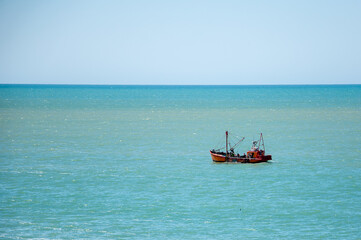 fishermen from a coastal fishing boat collecting the net in the sea