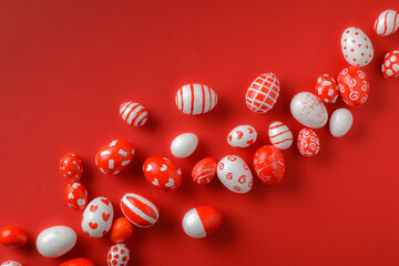 Easter backgrounds, scattered Easter red and white eggs on a bright red background. A place to copy. Flat position, top view