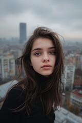 Young woman with a thoughtful expression overlooking a cityscape