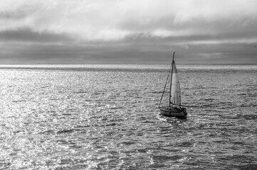 A sailboat sailing in the Atlantic Ocean under a stormy sky
