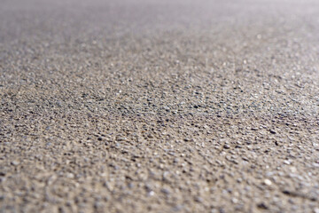 A close up of a grey concrete surface with small rocks scattered across it