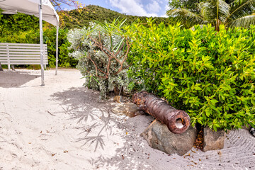 Tortola, British Virgin Islands - March 27, 2024: A rusted cannon on the beach at The Bight on Norman Island
