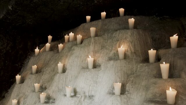Beautiful candles on cave-like wall - steady cam
