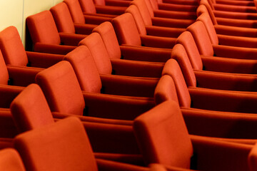 close rows of red armchairs in the conference room