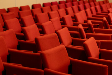 close rows of red armchairs in the conference room