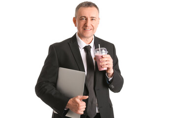 Mature businessman with glass of fruit smoothie and laptop on white background