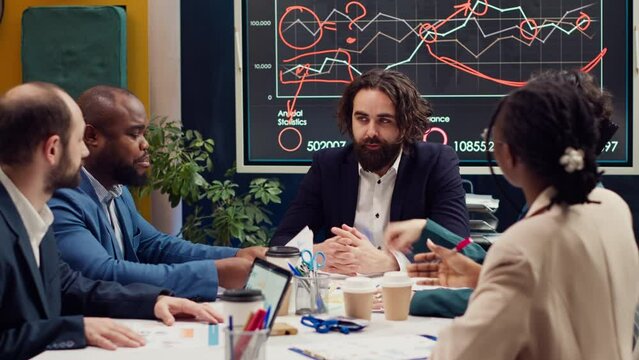 Startup team evaluating infographics data in an executive meeting, corporate restructuring or organizational changes. Adapting the organization to evolving market conditions. Camera A.