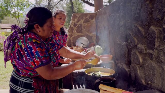 Latin woman adds spices to Creole chicken broth.