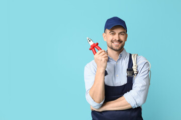 Portrait of male electrician with pliers on blue background