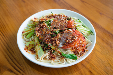 A bowl of delicious beef cold noodles on wooden table.