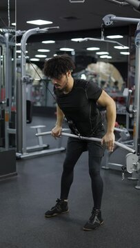 Young man exercising on lateral pull at gym for the back mucles