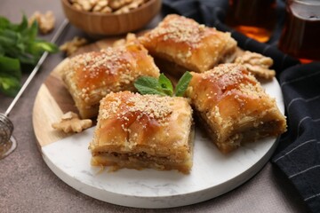 Eastern sweets. Pieces of tasty baklava on brown table, closeup