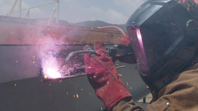 Job site welding metal beam with sparks