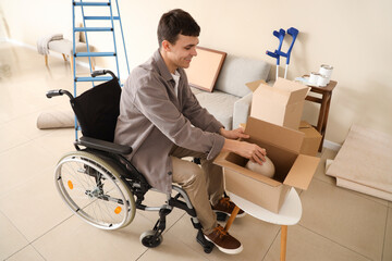 Young man in wheelchair packing vase during repair at home