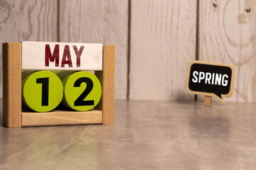 May 12th calendar date text on white wooden block with stationeries on wooden desk