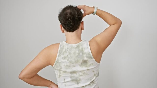 Pensive young man in sleeveless t-shirt standing with back turned, hand on head, wrestling with doubt over isolated white background