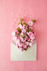 Mint envelope full of pink flowers. Flat lay. Love concept.