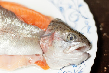 Close-up of a raw trout. A filleted fish on a white plate.