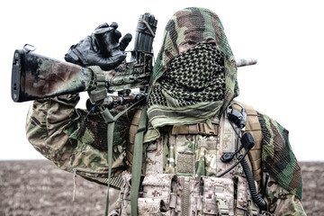 Army sniper standing in field with rifle