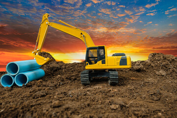 Crawler Excavator is digging soil in  construction site with  pipeline work on sunset backgrounds. - obrazy, fototapety, plakaty