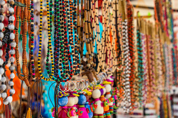 Craft market in Cuenca. Various colorful necklaces made of beads and wood. Selective focus. Ecuador