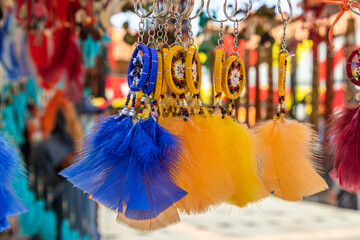 Colorful blue and yellow dream catchers with bird feathers at a craft market, Ecuador. Selective...