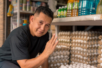 An asian store owner making an ok sign while crouching down. An egg trader or retailer. - obrazy, fototapety, plakaty