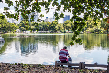 Man sat by the lake in Lumphini Park