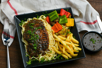 Grilled thick cultured juicy steak in a special pepper sauce along with tender pasta, French fries...