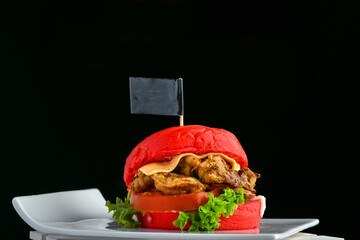 Prawns marinated fried red color bun burger with spices, veggies and sauce
